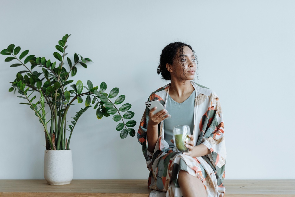 Woman with ZZ Plant in minimalist room with low light